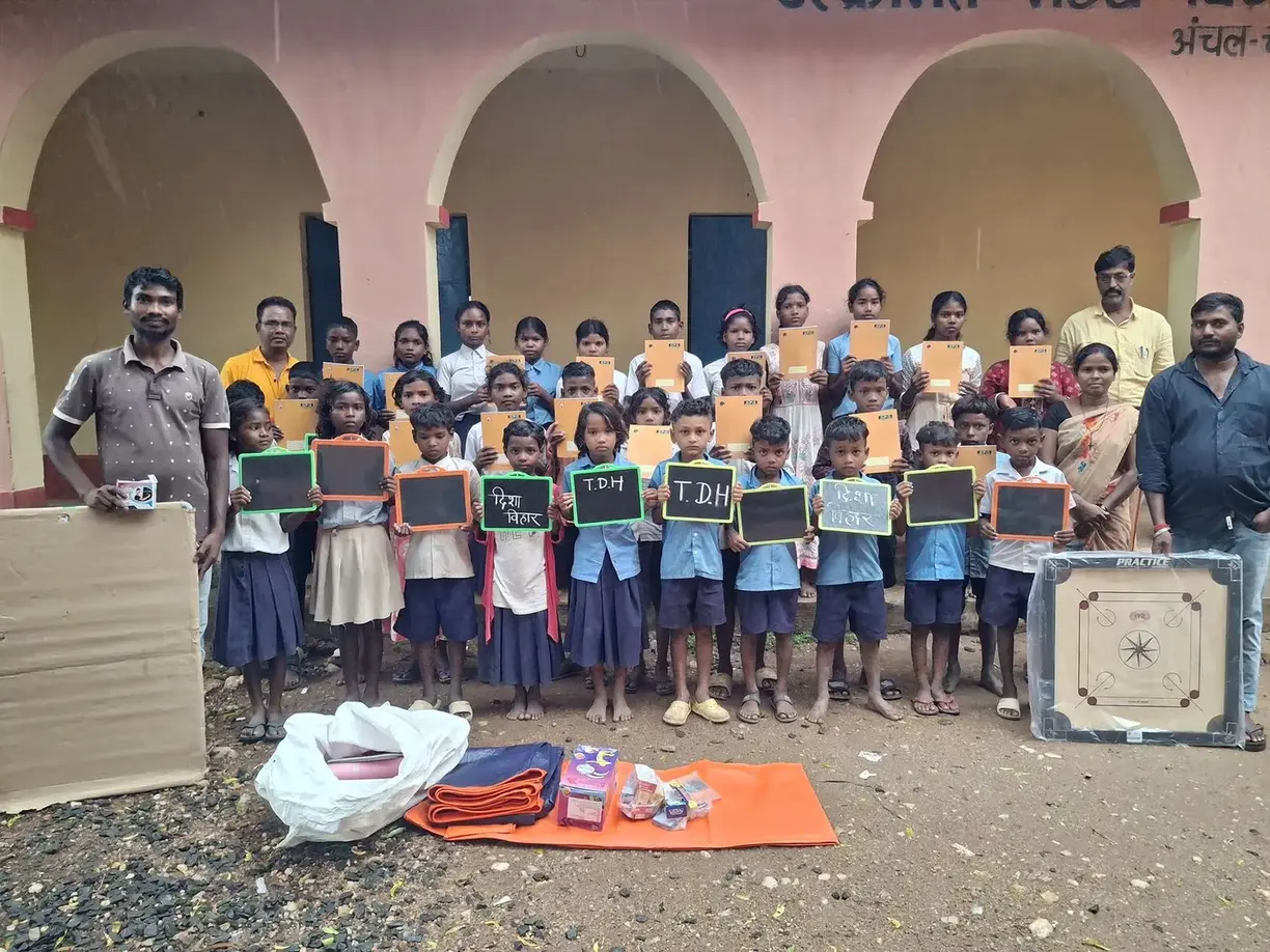 School materials distribution — children holding slates and notebooks from Disha Vihar & TDH - slide 1