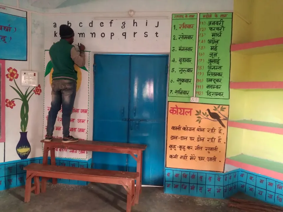 Volunteer preparing educational charts and materials for classroom walls - slide 1